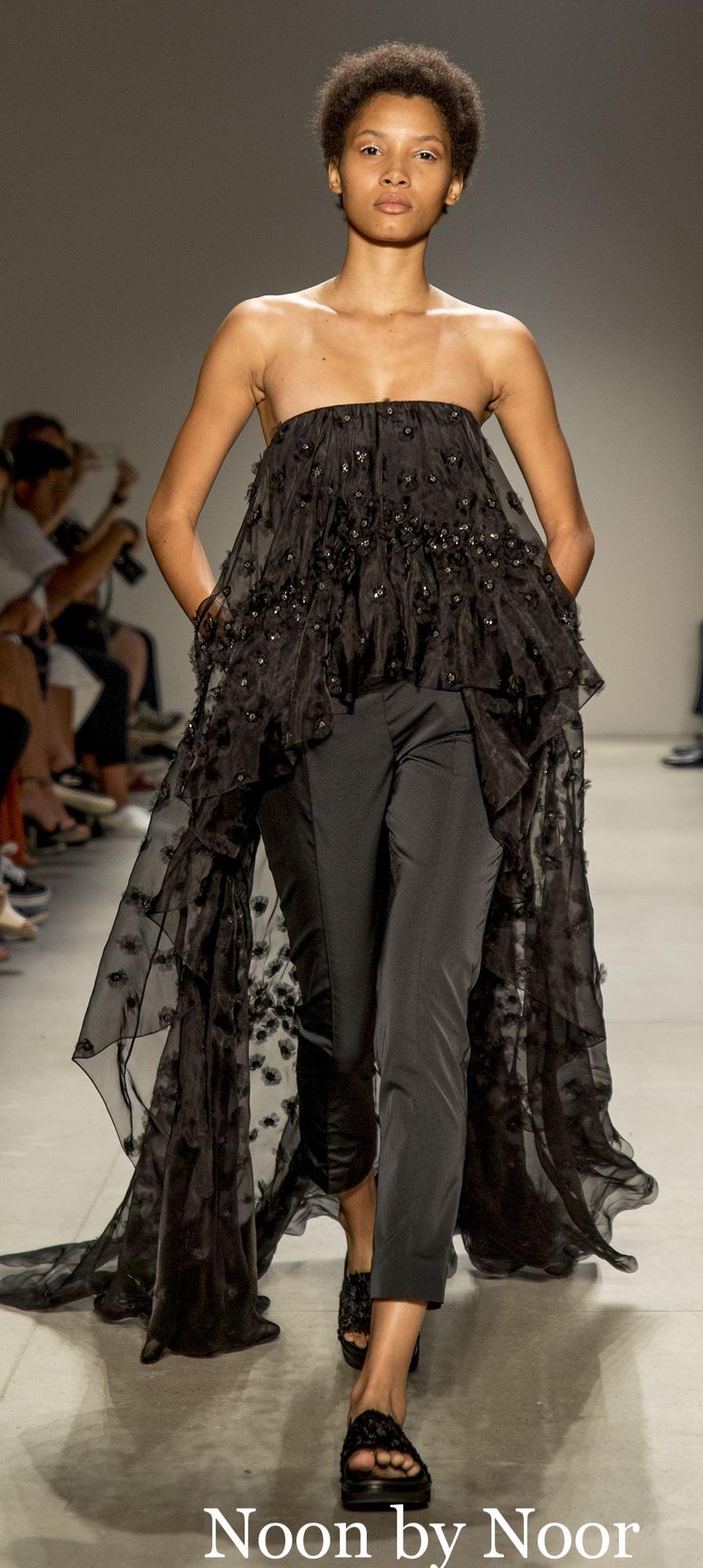 Model walking in a black strapless ruffled tunic over trousers at Noon by Noor SS17